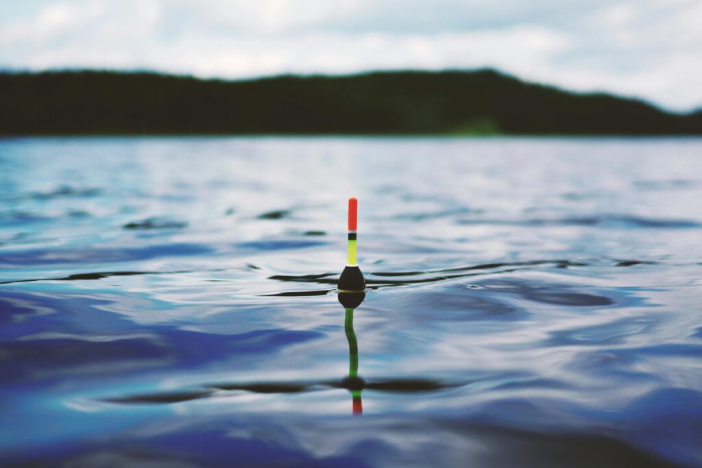 pexels photo 190294 190294 Vibrant fishing float gently resting on a serene blue water surface, ideal for travel and nature themes.